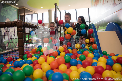 Image of Young mom with her kids in a children\'s playroom