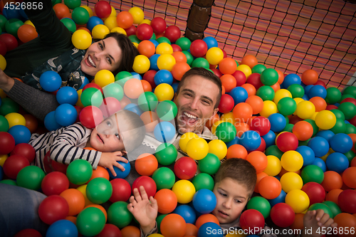 Image of young parents with kids in a children\'s playroom