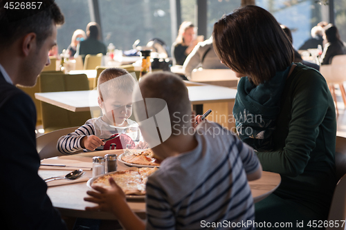 Image of Young parents enjoying lunch time with their children