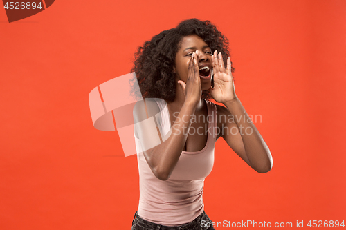 Image of Isolated on red young casual afro woman shouting at studio