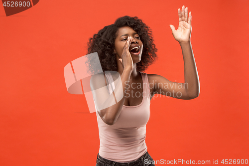 Image of Isolated on red young casual afro woman shouting at studio