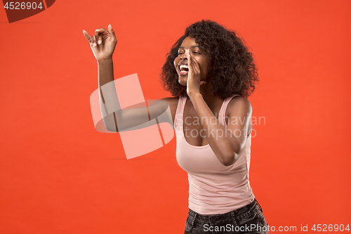 Image of Isolated on red young casual afro woman shouting at studio