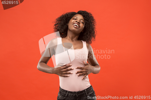 Image of The happy business woman standing and smiling against red background.