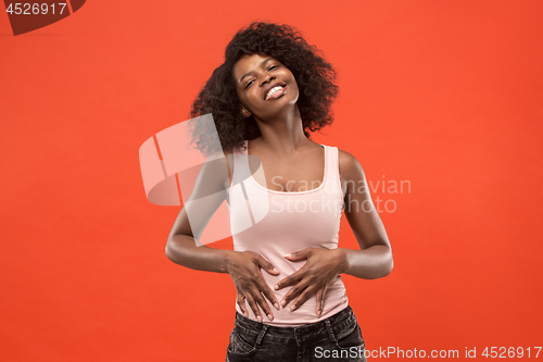 Image of The happy business woman standing and smiling against red background.