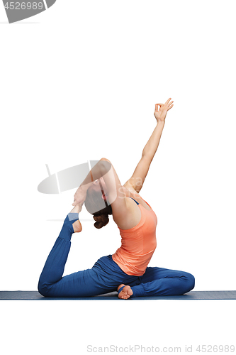 Image of Woman doing Hatha yoga asana Eka pada rajakapotasana 