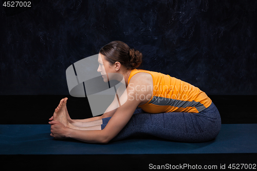 Image of Woman doing Hatha yoga Ashtanga Vinyasa yoga asana Paschimottana