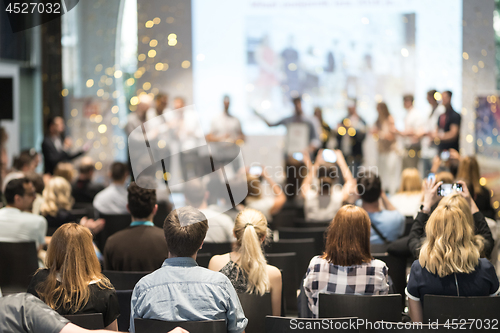 Image of Young business team receiving award at best business project competition event.