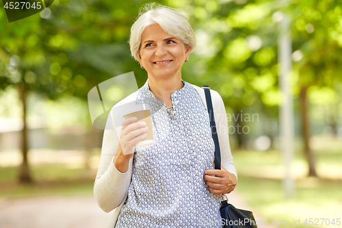 Image of senior woman drinking takeaway coffee at park