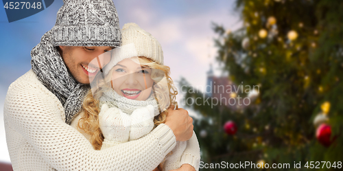 Image of happy couple hugging over christmas tree