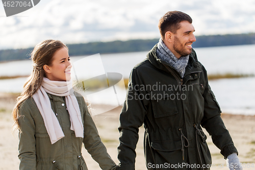 Image of couple walking along autumn beach