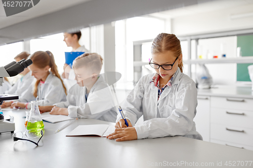 Image of teacher and students studying chemistry at school