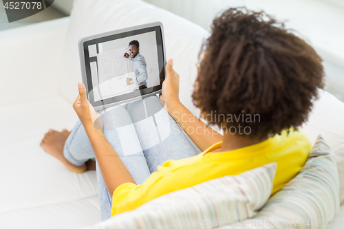 Image of woman watching webinar on tablet computer at home