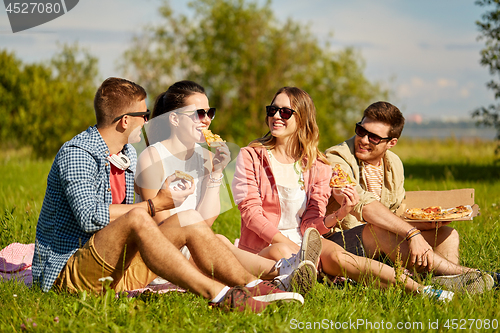 Image of friends eating pizza at picnic in summer park