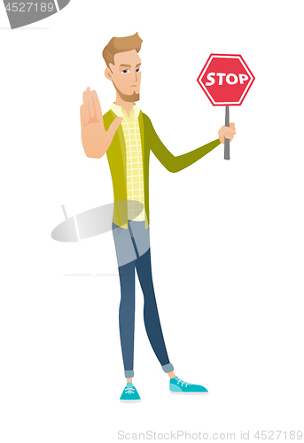 Image of Young caucasian businessman holding stop road sign