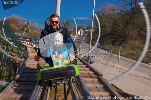 Image of young father and son driving alpine coaster