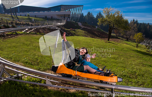 Image of young mother and son driving alpine coaster