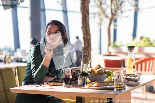 Image of young woman  having lunch at restaurant