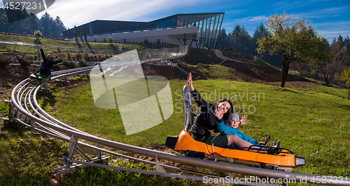 Image of young mother and son driving alpine coaster