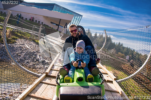 Image of young father and son driving alpine coaster