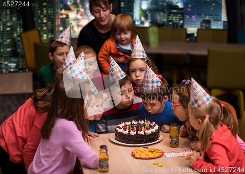 Image of happy young boy having birthday party