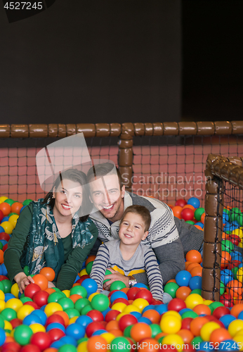 Image of parents and kids playing in the pool with colorful balls