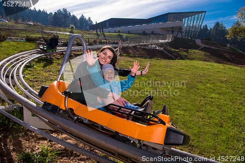 Image of young mother and son driving alpine coaster