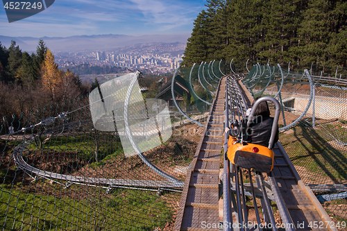 Image of young mother and son driving alpine coaster