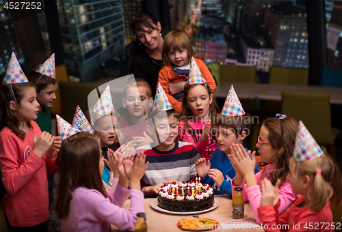 Image of happy young boy having birthday party