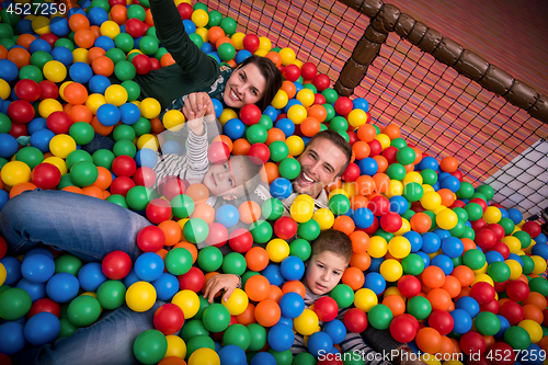 Image of parents and kids playing in the pool with colorful balls