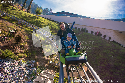 Image of young father and son driving alpine coaster