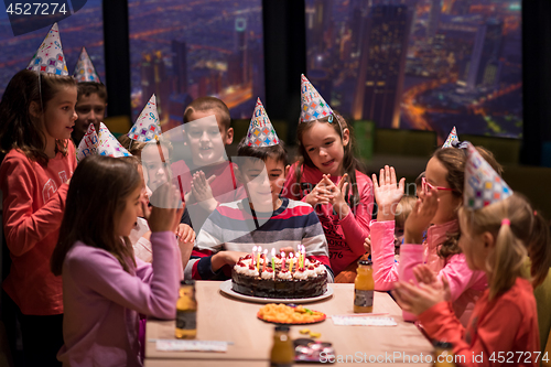 Image of happy young boy having birthday party