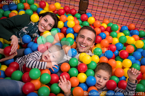 Image of parents and kids playing in the pool with colorful balls