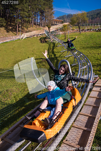 Image of young mother and son driving alpine coaster