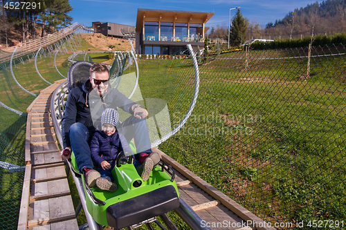 Image of young father and son driving alpine coaster