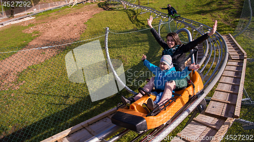 Image of young mother and son driving alpine coaster