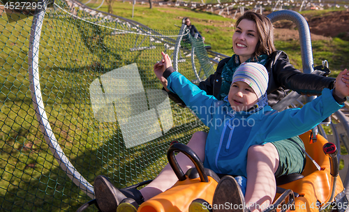 Image of young mother and son driving alpine coaster