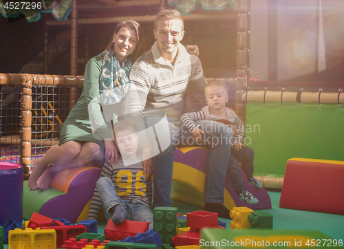 Image of young parents and kids having fun at childrens playroom