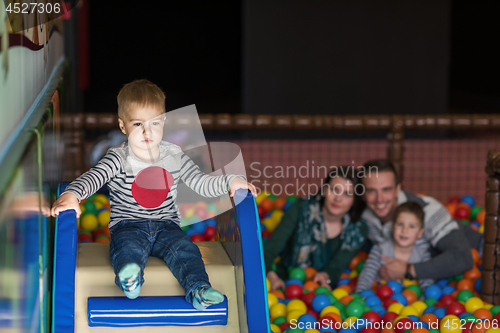 Image of parents and kids playing in the pool with colorful balls