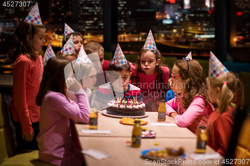 Image of happy young boy having birthday party