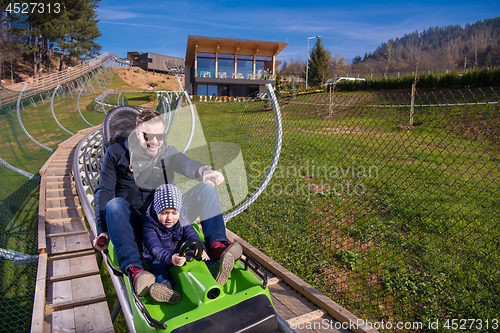 Image of young father and son driving alpine coaster