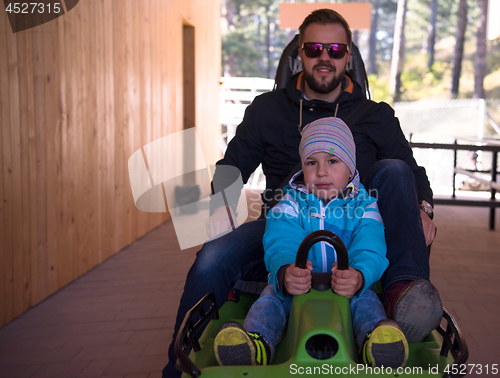 Image of young father and son driving alpine coaster