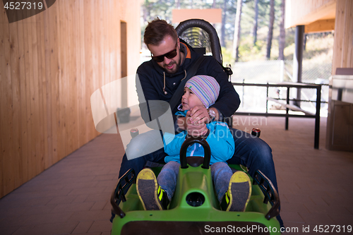 Image of young father and son driving alpine coaster