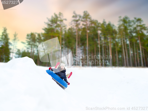 Image of happy teenage girl sliding down hill on snow tube