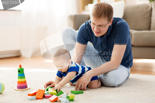 Image of happy father with baby son playing toys at home