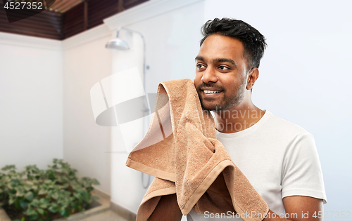 Image of smiling indian man with bath towel over shower