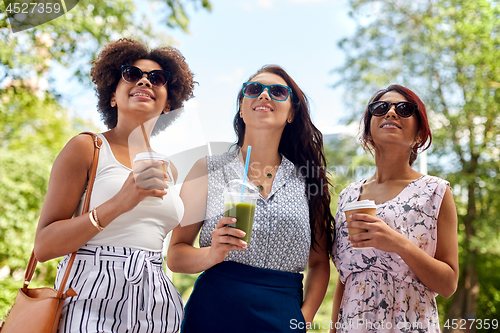 Image of happy women or friends with drinks at summer park