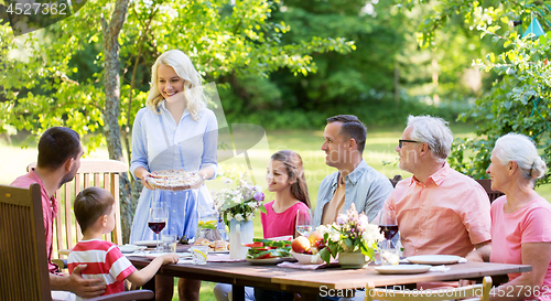 Image of happy family having dinner or summer garden party