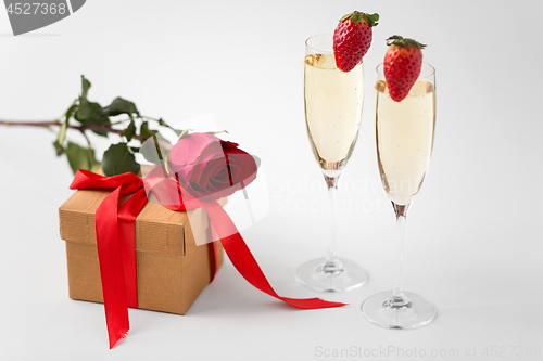 Image of two champagne glasses and gift with red rose