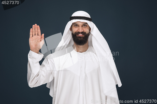 Image of Arabian saudi businessman on dark blue studio background