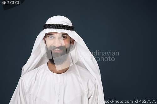 Image of Arabian saudi businessman on dark blue studio background